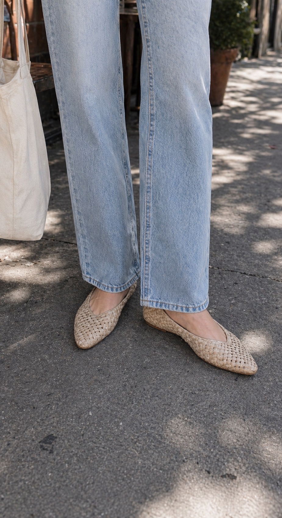 Mild-Weather Weekend Outfit: a linen shirt, straight jeans, and woven flats shoe and hem detail: Relaxed white linen shirt, Ivory ribbed tank top, Light-wash straight-leg jeans, Natural woven flats, Canvas market tote styling reference image