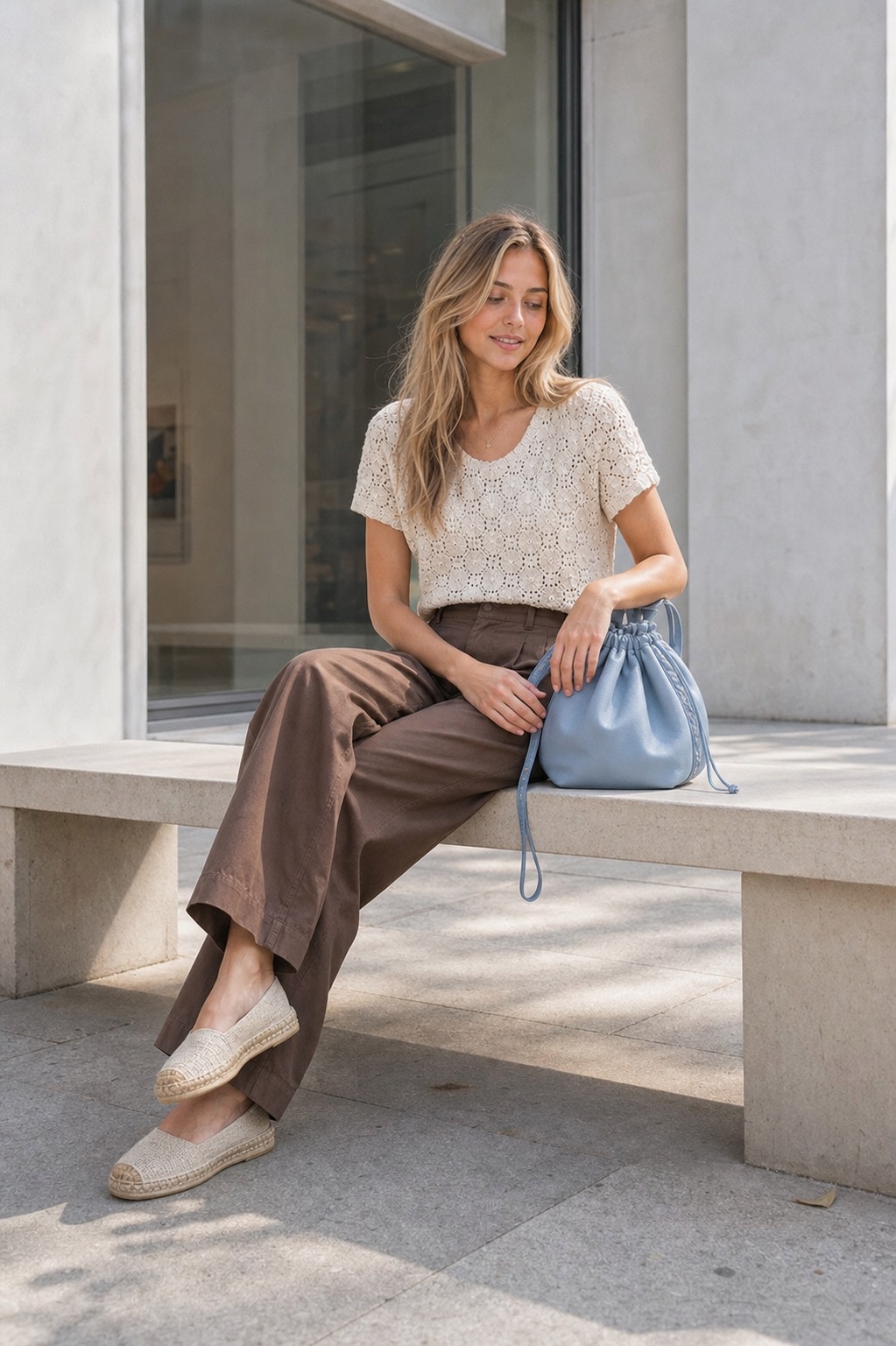 Light Trail Outfit: a crochet top, poplin pants, and espadrilles seated outfit styling: ivory crochet short-sleeve top, cocoa poplin wide-leg pants, natural espadrille flats, sky-blue drawstring bag styling reference image