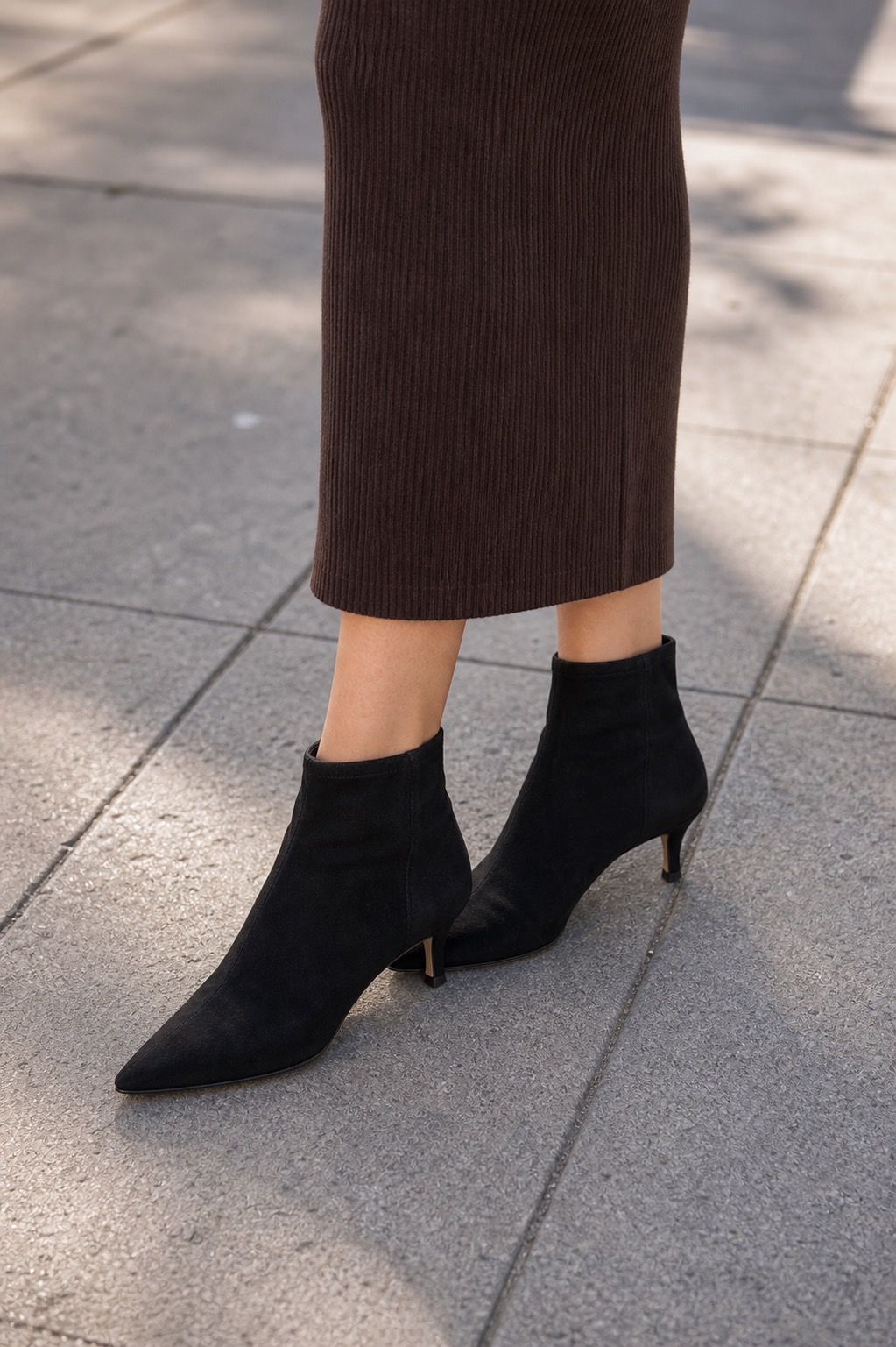 Spring Gallery Outfit: a column dress, cropped jacket, and shoulder bag shoe and hem detail: Espresso ribbed knit column midi dress, Bone cropped denim jacket, Black suede kitten-heel ankle boots, Cognac east-west shoulder bag, Layered fine gold chain necklace styling reference image