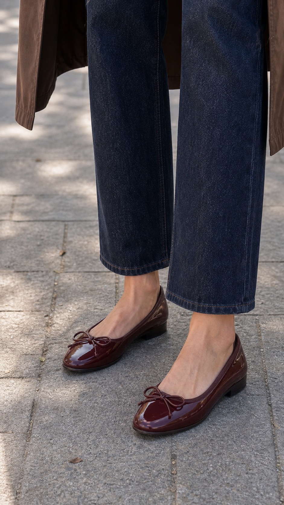 Home Goods Errand Outfit: a chocolate trench, dark denim, and burgundy flats shoe and hem detail: Chocolate water-resistant trench coat, Cocoa ribbed knit polo top, Dark indigo straight-leg jeans, Burgundy water-resistant ballet flats, Olive nylon crescent shoulder bag styling reference image
